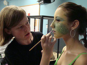One girl applying makeup to another